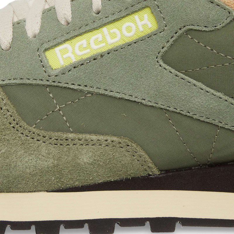 Close-up of the Reebok Classic Leather Premium LTD Shoes in green, highlighting suede and fabric textures, beige midsole, and a yellow patch with white Reebok logo—ideal for retro sneaker enthusiasts and lovers of classic silhouettes.