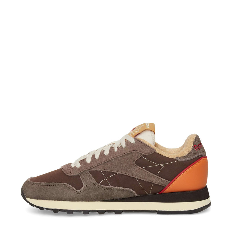 The Reebok Classic Leather Premium LTD Shoes feature brown and tan suede and fabric panels, white laces, a cream sole, orange heel detail, and red "HOFF" text on the heel. Shown from the side on a plain white background.