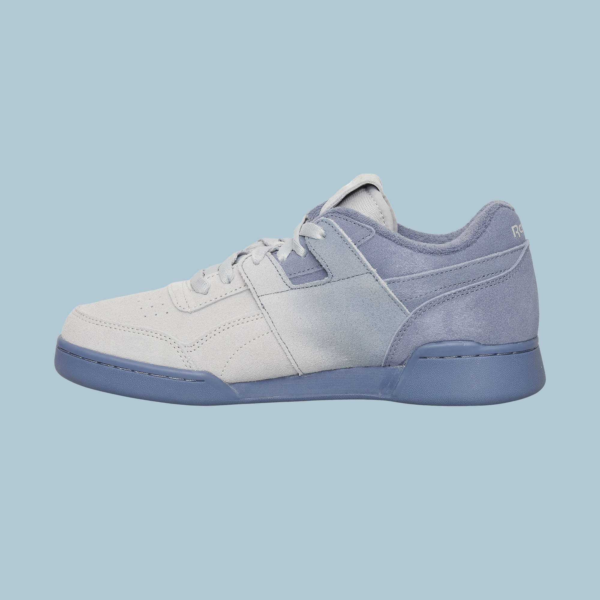 The Reebok Workout Plus OG Shoes feature a light blue and white gradient design with a blue sole, subtle heel branding, and classic silhouette, showcased on a light blue background.