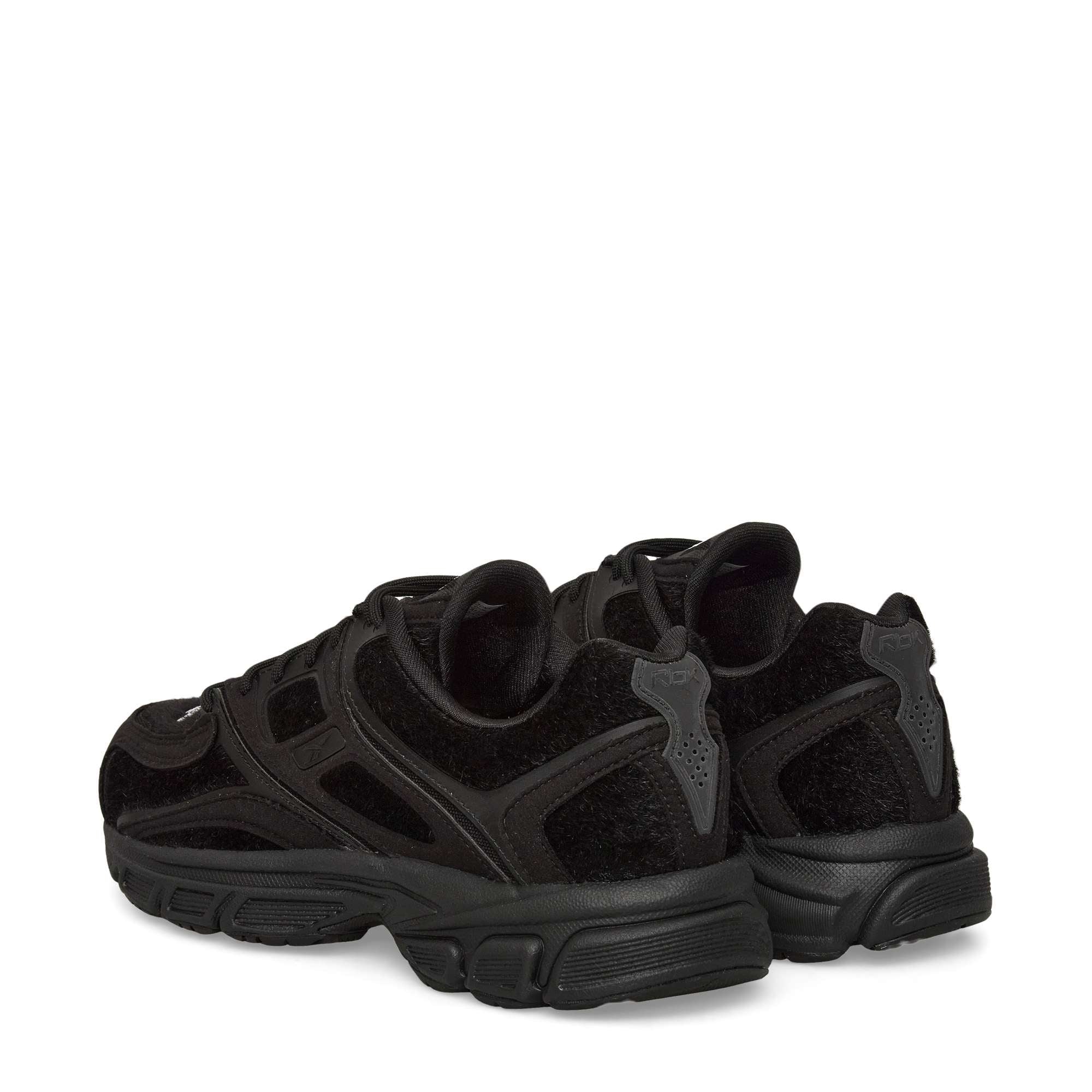 A pair of black athletic sneakers with textured suede details and thick, chunky soles, shown from a rear angle on a plain white background.
