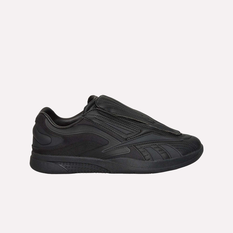 A side view of the Reebok Hammer Pro LTD Shoes showcases a black low-top silhouette with a sleek, layered design and a covered lace area, featuring a faux leather upper and durable rubber sole, set against a plain white background.