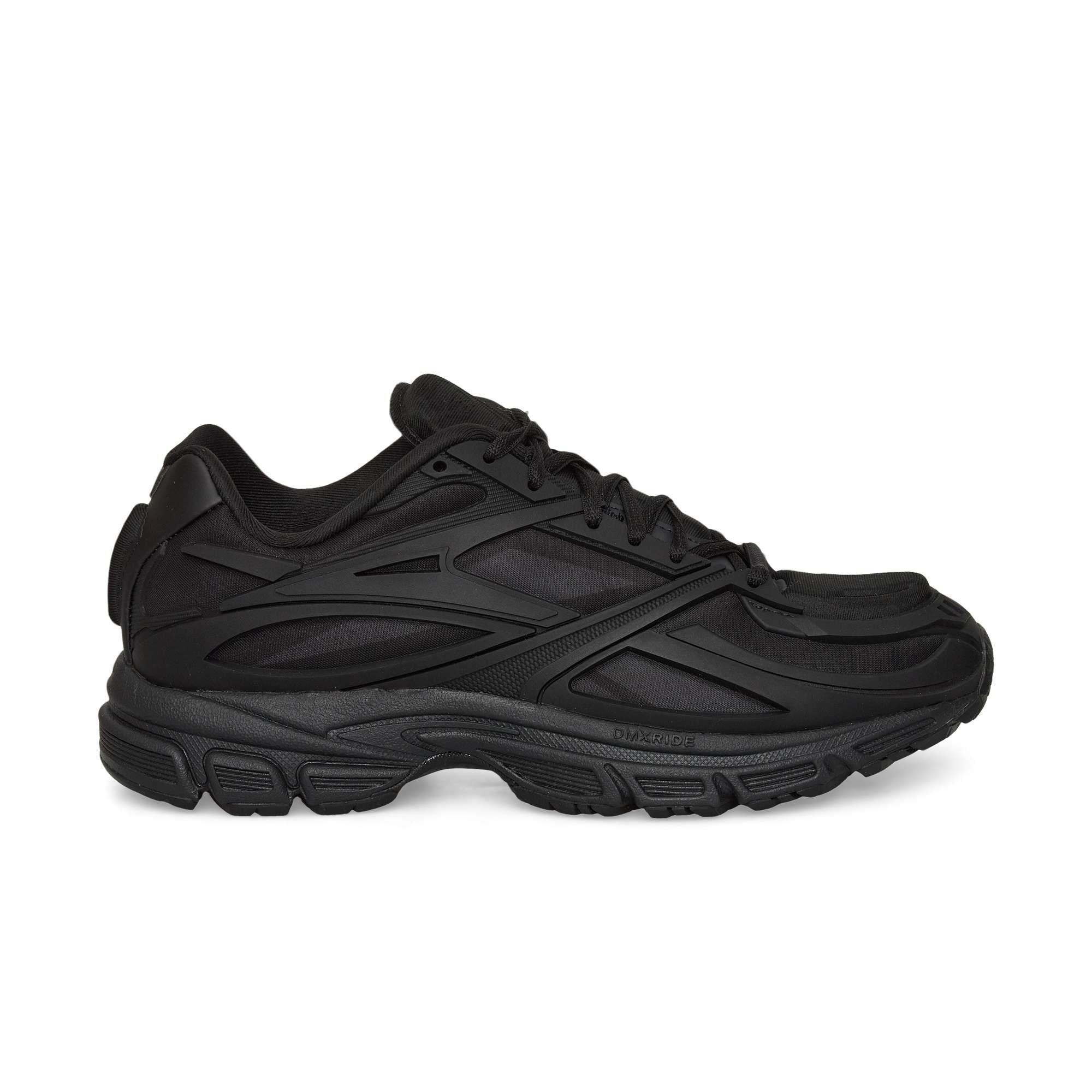 A black Reebok Premier Road Modern running shoe with a chunky sole and layered, textured side details is shown from the left against a white background.