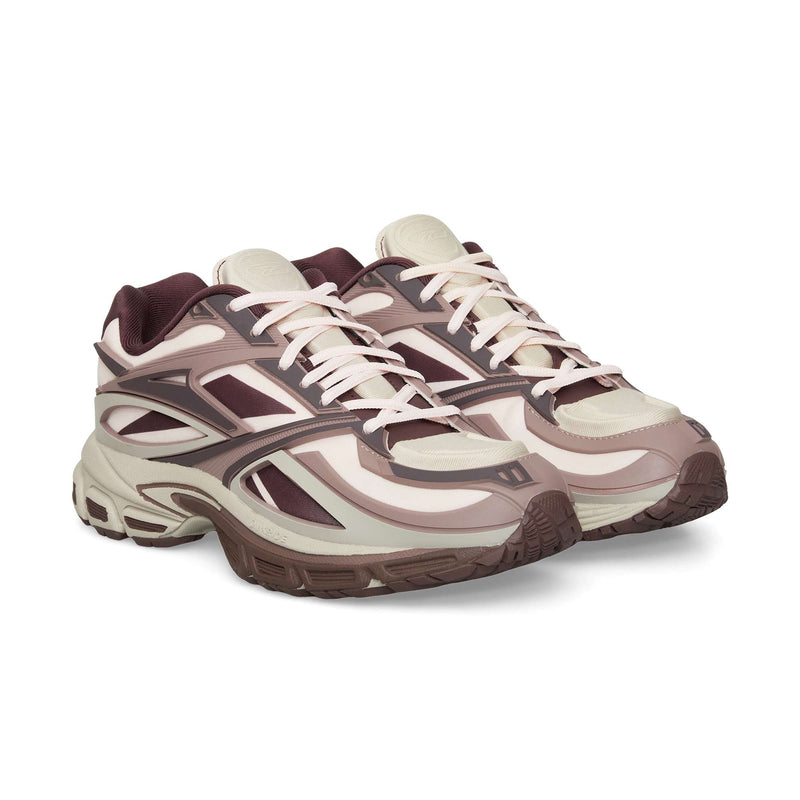 A pair of Reebok Premier Road Modern sneakers with beige, cream, and maroon accents, thick dual-density midsoles, patterned panels, and white laces are displayed side by side on a white background.