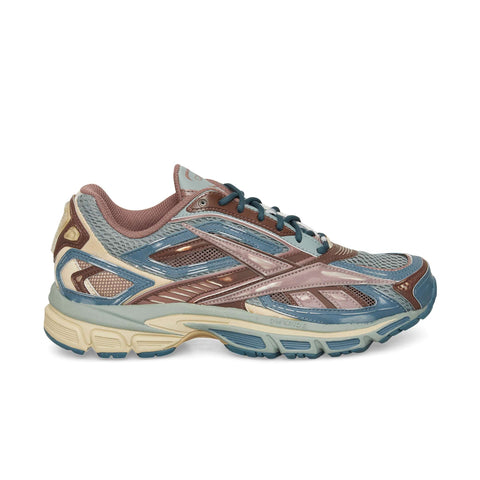 The Reebok Premier Road Ultra, a multicolored running sneaker with blue, brown, beige, and pink accents, mesh upper, and dual-density cushioned midsole, is displayed in side profile against a white background.