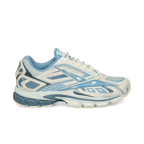 The Reebok Premier Road Ultra is a light blue and white running sneaker featuring mesh panels, synthetic overlays, a dual-density midsole, and a rubber sole, shown in a side view against a white background.