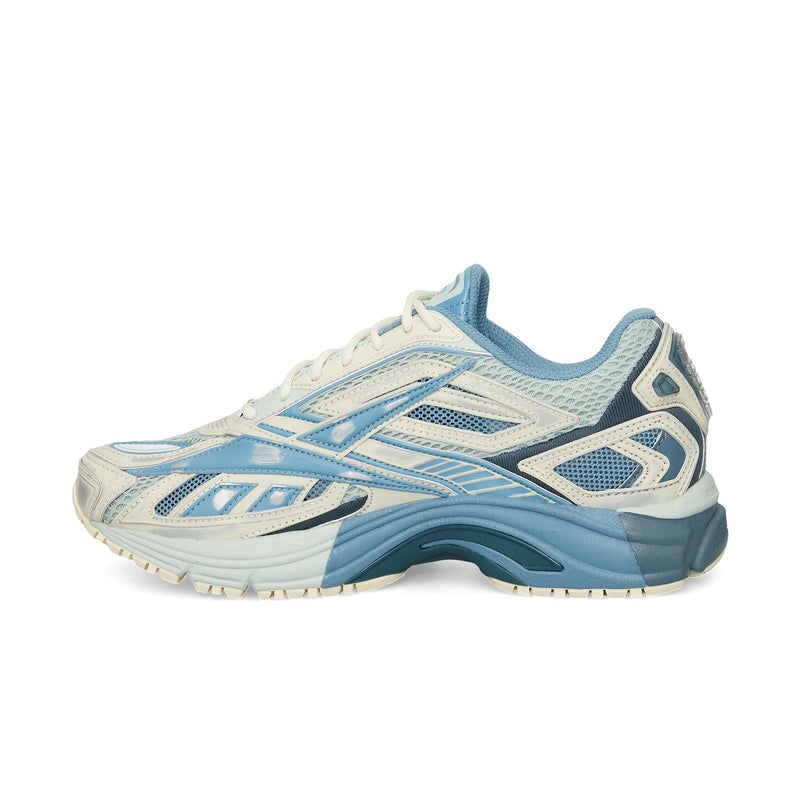 The Reebok Premier Road Ultra is a light blue and cream running sneaker with mesh and synthetic overlays, a dual-density midsole, chunky sole, and an angular design.