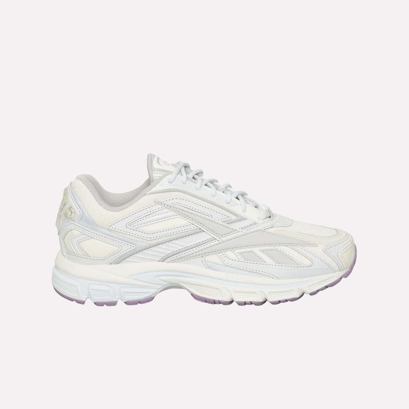 A white athletic sneaker with light gray accents, a textured sole, and lace-up closure is displayed on a plain white background. The Reebok Premier Road Ultra LTD Shoes are inspired by archival running sneaker design and feature a supportive dual-density midsole for enhanced comfort and performance.