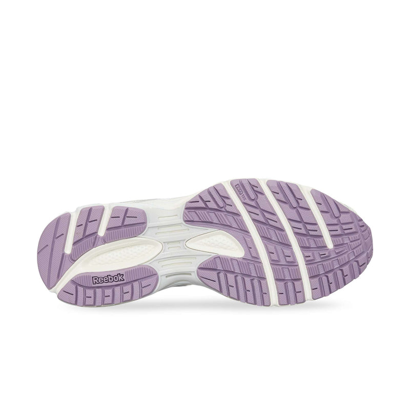 The image displays the sole of the Reebok Premier Road Ultra, featuring light purple and white rubber treads with grooves for traction. The Reebok logo appears on the bottom left.