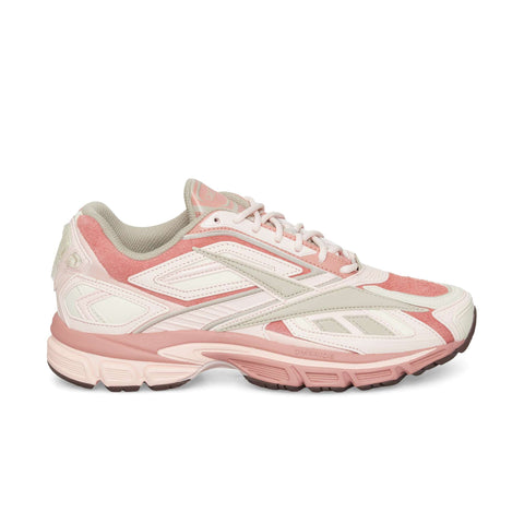 The Reebok Premier Road Ultra, a pink and white sneaker with suede and mesh details, dual-density midsole, chunky sole, and white laces, is shown against a plain white background.
