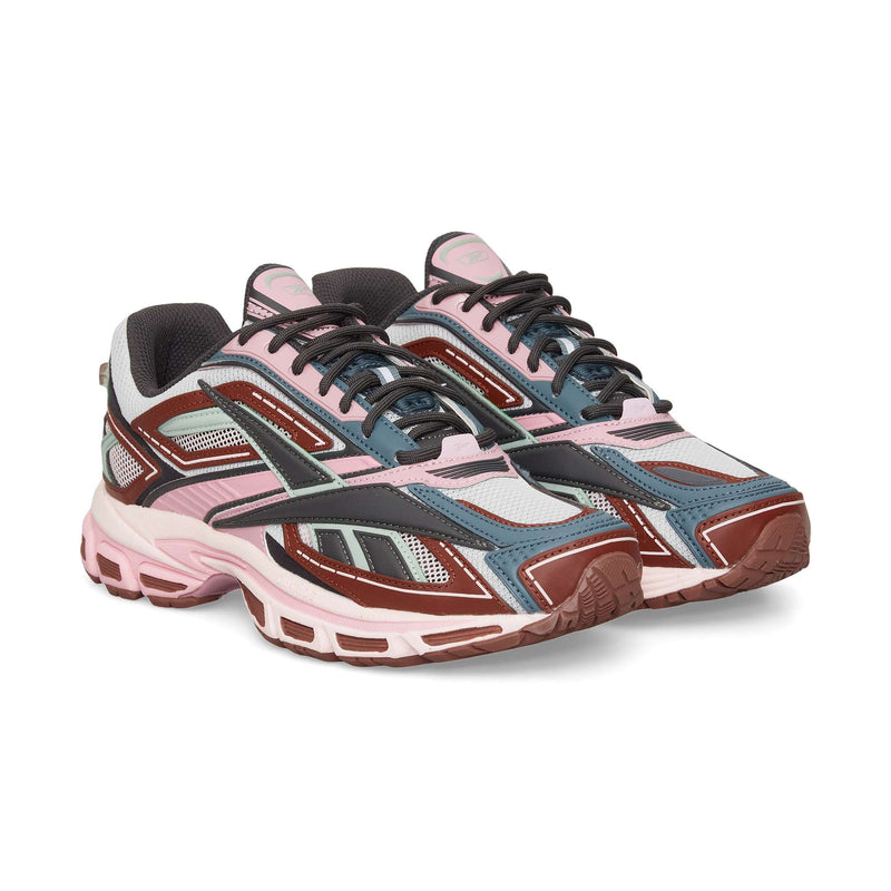 The Reebok Premier Road Ultra is a stylish archival running sneaker featuring pink, maroon, grey, blue, and black colors with mesh panels, chunky soles, a dual-density midsole, and detailed overlays.