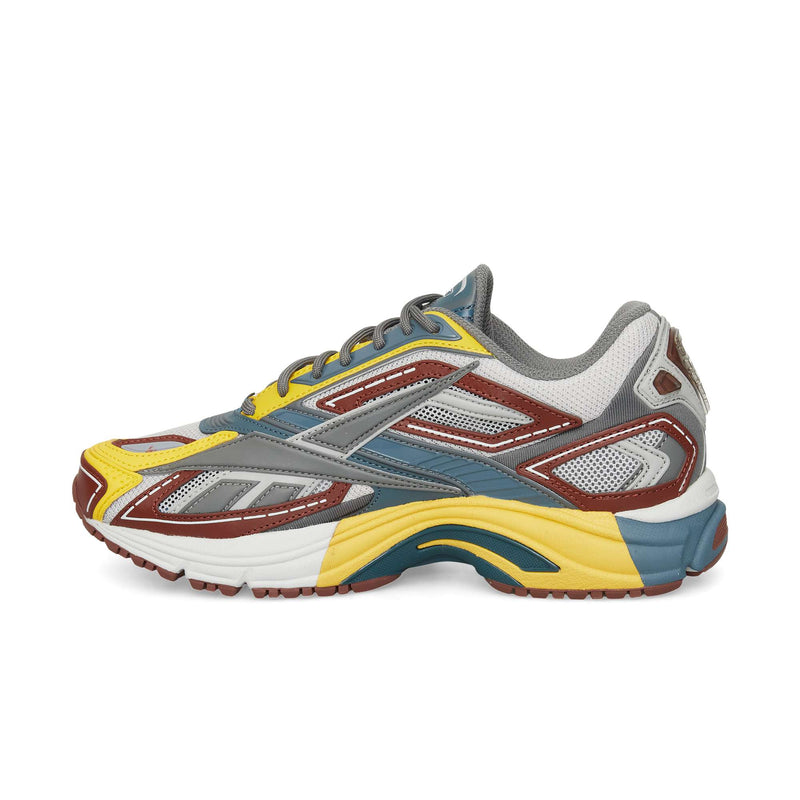 The Reebok Premier Road Ultra is a colorful running sneaker featuring yellow, brown, gray, blue, and white panels with mesh accents and a thick dual-density midsole for sporty modern style.