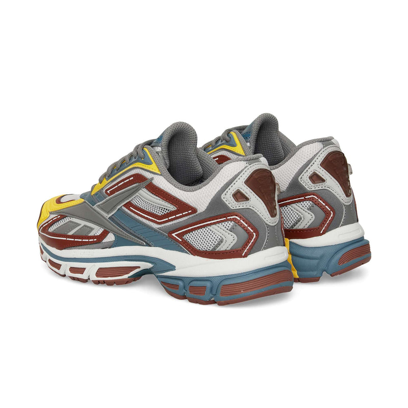 A pair of Reebok Premier Road Ultra sneakers featuring multicolored yellow, brown, gray, white, and blue accents are shown side by side, highlighting the backs and sides of these archival running shoes.
