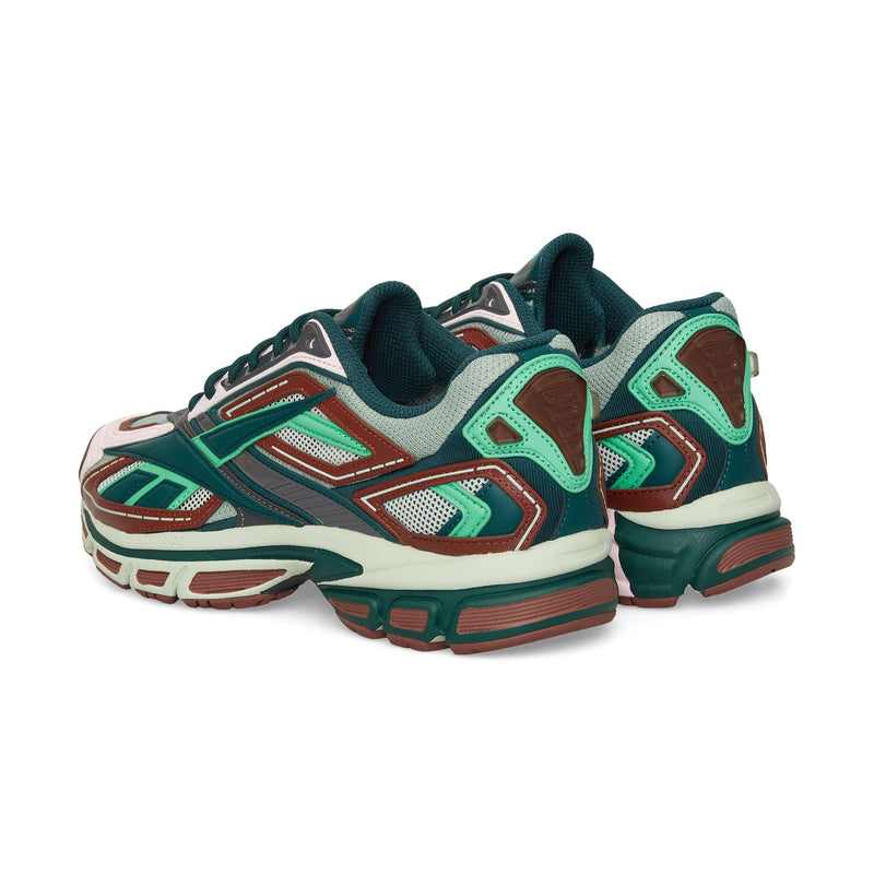 The Reebok Premier Road Ultra sneakers feature a stylish mix of green, teal, brown, and white, displayed from a rear side angle on a white background.