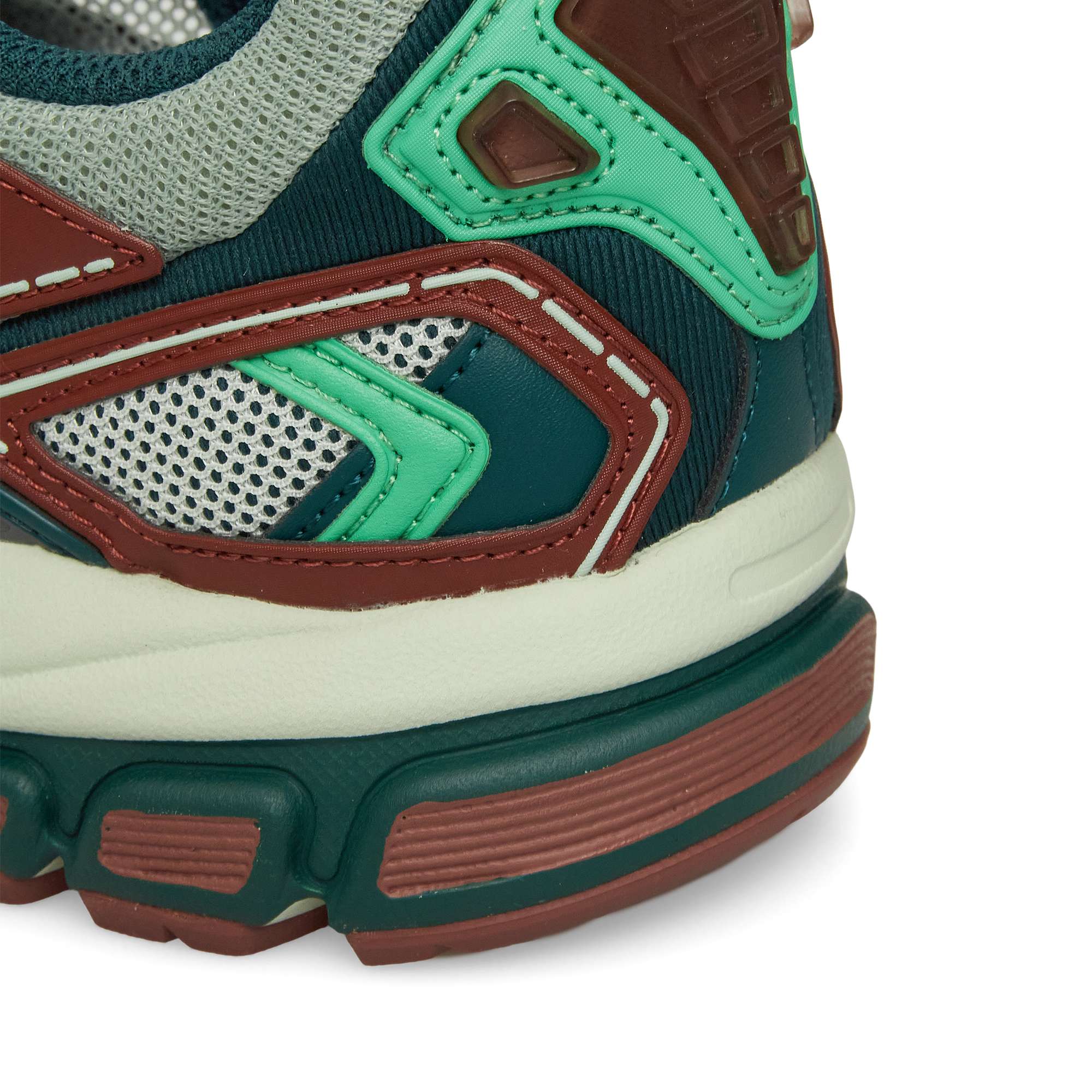 Close-up of the Reebok Premier Road Ultra heel and midsole, showcasing green, brown, off-white, and grey colors with mesh and synthetic overlays, intricate stitching, and a dual-density midsole.