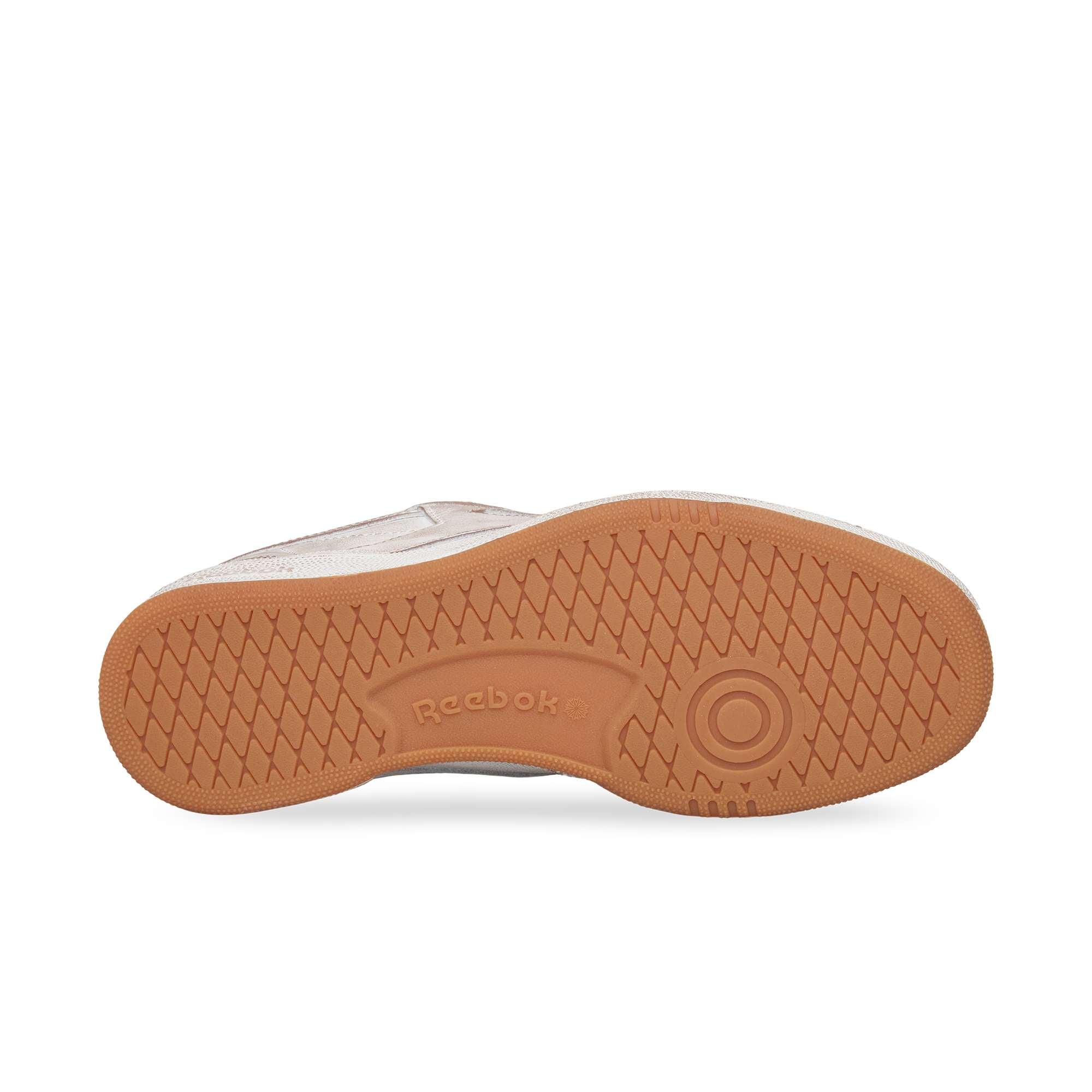 The image shows the sole of the Reebok Club C 85 Vintage, featuring a light brown rubber outsole with a diamond-textured tread pattern and an embossed Reebok logo—an iconic lifestyle classic.