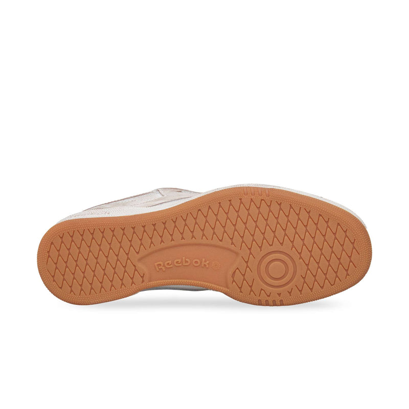 The image shows the sole of the Reebok Club C 85 Vintage, featuring a light brown rubber outsole with a diamond-textured tread pattern and an embossed Reebok logo—an iconic lifestyle classic.