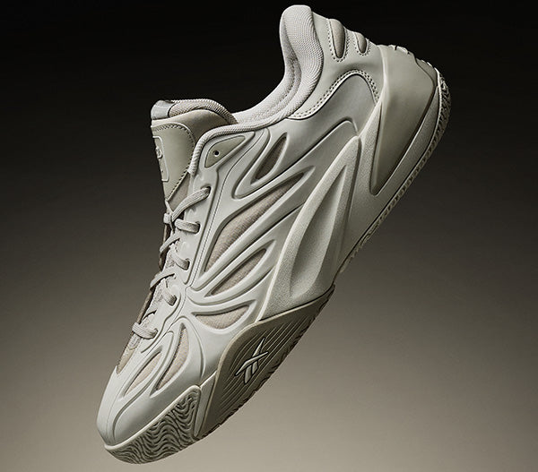 Gray athletic shoe on a dark background