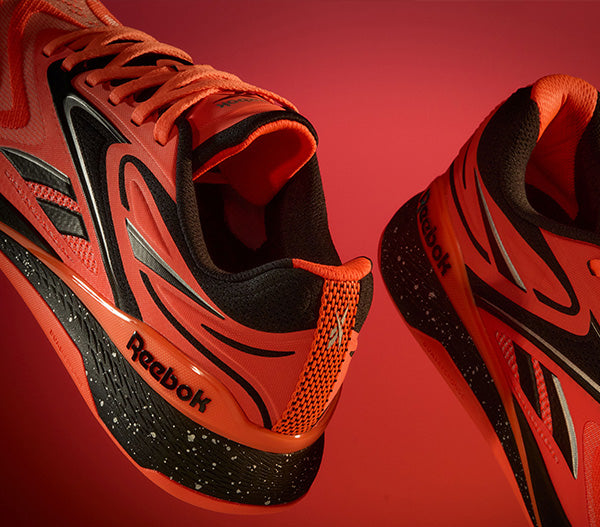 Red and black Reebok running shoes on a red background