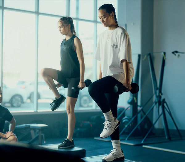 2 people lifting weights in a gym
