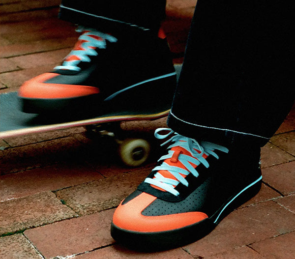 orange and black sneakers on a skateboard