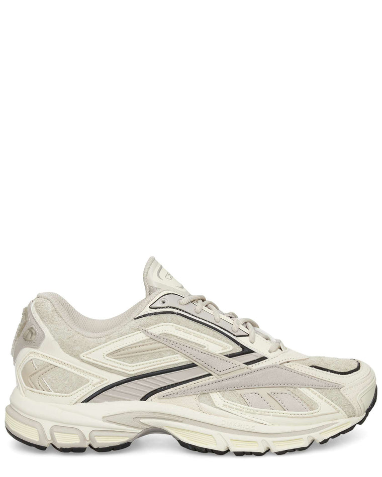 The Reebok Premier Road Ultra Shoes in beige and white feature mesh and suede panels with black accents and a chunky dual-density midsole, shown in side profile against a white background.